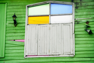 Colorful Wooden Window Shutters on Green Wall with Decorative Lights