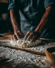 Close-Up of Baker's Hands Kneading Flour Dough for Fresh Bread in a Moody Rustic Setting