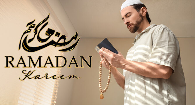 Young Muslim man with Koran and tasbih praying at home. Ramadan celebration