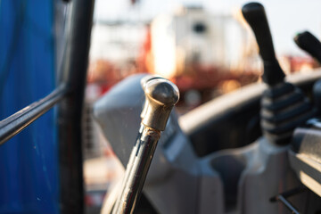 Close-up at backhoe or excavator machine controlling handle at the driver cabin, it using to operate the machine. Industrial equipment object, selective focus.