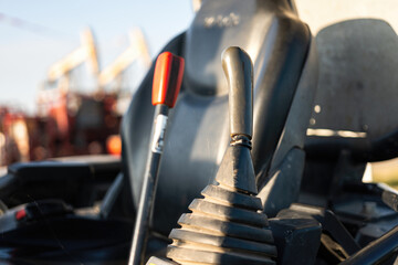 Close-up at backhoe or excavator machine controlling handle at the driver cabin, it using to operate the machine. Industrial equipment object, selective focus.