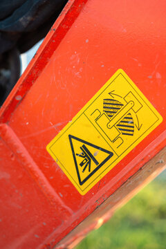 Safety caution sign on the backhoe front part, instruciton for keep out from the swing radius to prevent the accident. Safety sign on the industrial machine, close-up.