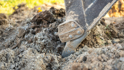 An excavator or backhoe machinery part with soil ground in construction activity. Building...