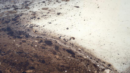 Dirty water contaminated with crude oil that drained into the public water supply, close-up at the water surface. Industrial problem and environmental impact issue, background.