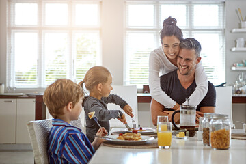 Hug, happy parents and children with breakfast in home for nutrition, hungry and healthy relationship. Family love, people and kids with morning meal at dining table for wellness, bonding and embrace
