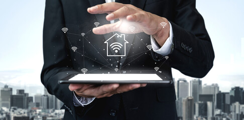 A businessman in a suit interacts with a tablet displaying smart home technology symbols, set against a modern urban skyline, symbolizing innovation and connectivity. Gantry