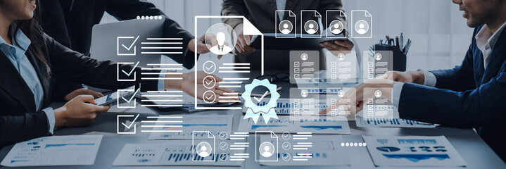 A group of professionals engaged in a meeting, utilizing digital tools and checklists to enhance productivity and collaboration in a modern office setting. Gantry