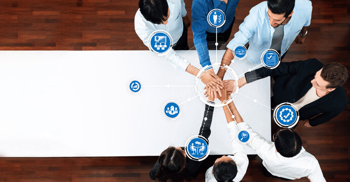 Aerial view of diverse professionals engaged in active teamwork, demonstrating collaboration and management strategies to achieve common business goals at a conference table. Amity