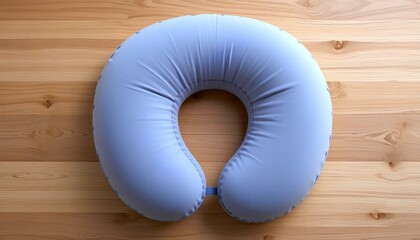 A blue color neck pillow is presented on a wooden background representing mockup