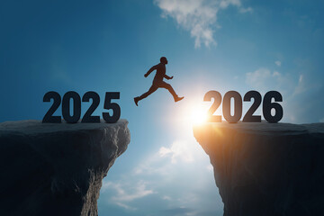Silhouette of a man jumping from the cliff of 2025 to 2026 at sunset.
