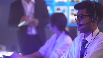 Professional technical support team managing customer service in a 24/7 data center. Operators handling client calls and troubleshooting software issues while monitoring digital data at night.