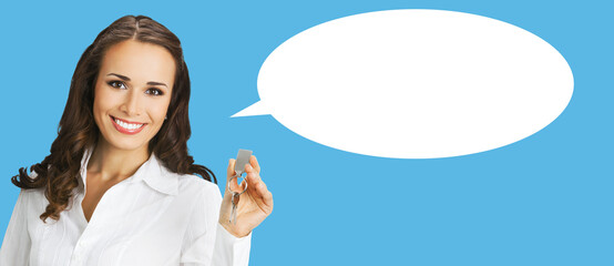 Happy smiling businesswoman or real estate agent showing keys from new house. Portrait of brunette...