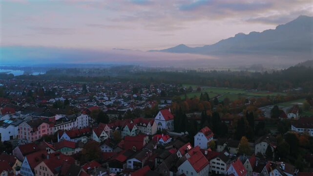 Tegelberg Forggensee F&uuml;ssen Fussen birds Allg&auml;u Bavarian Alps Germany Deutschland aerial drone Lech River Bavarian old town buildings autumn fall morning sunrise blue sky fog forwards motion