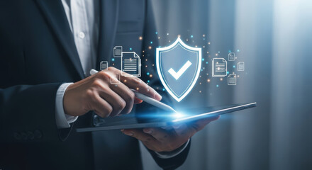 A businessman interacts with a tablet displaying a shield icon with a checkmark surrounded by security icons in a business environment