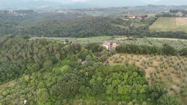 Aerial views of houses on a hill in Impruneta near Florence, Italy, featuring the rolling hills of the scenic Tuscan landscape. On a beautiful summers day.