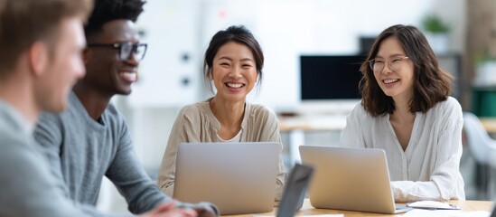 Diverse Team Collaborating Around Laptops in Bright Office Setting