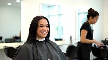 A smiling woman at a salon is about to get her hair done by a stylist