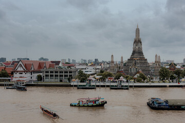 Bangkok, Thailand - June 11, 2025: Evening view of tourists watching the sunset along the Chao Phraya River at Wat Arun.