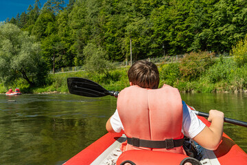 Kayaking on the Poprad River surrounded by green forest landscape