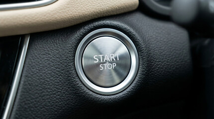 Close up of car ignition button with start stop text on silver metallic surface surrounded by black leather interior