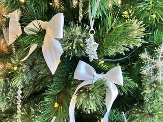 Elegant White Bow and Crystal Ornaments on Christmas Tree with Warm Lights