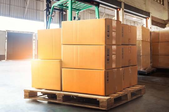 Package Boxes Stack on Pallets in Warehouse. Cartons, Cardboard Boxes. Storage Warehouse. Supply Chain, Supplies Goods Shipment. Shipping Warehouse Logistics.	
