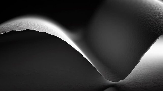 Textured paper curling upward, creating graceful wave silhouette with dramatic light shadow contrast on minimalist monochrome surface