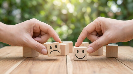 Close up of hands picking a wooden cube with a happy smiley face instead of a sad face,concept of positive thinking,mental health,emotional transition,feedback,and customer service.