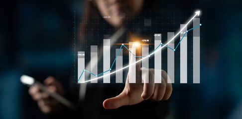 A business professional interacts with a digital graph on a touchscreen, showcasing financial growth and trends for better performance analysis in a modern office setting. Impute