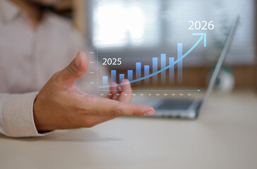 Businessman holding graph and upward arrow from 2025 to 2026, representing data-driven business growth, strategic planning, performance forecast, annual success and financial improvement.