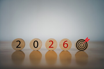 Wooden blocks displaying the year 2026 with a target icon symbolizing future goals, business planning, strategic objectives, and long-term vision for success in the upcoming year