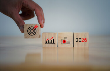 Wooden blocks displaying business growth icons, financial savings symbols, a target goal, the year 2026, representing future planning, economic strategy, investment forecasting, long-term objectives.