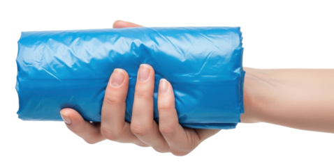 A hand holding a roll of blue plastic trash bags, isolated on white background.