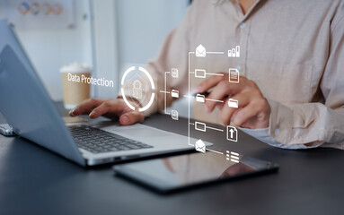 Hand pointing to digital data protection interface on laptop screen, with secure shield icon and network diagram. Concept for cybersecurity, cloud storage, and secure data access.