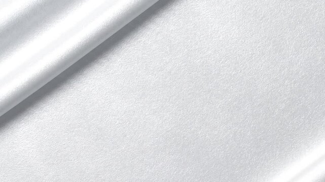 Close-up of folded white fabric with smooth folds on a plain white surface with soft shadows.