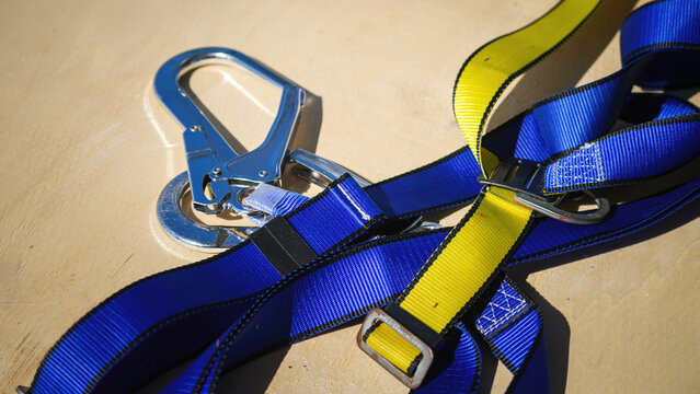 Safety harness device, falling prevention PPE to wear when working at height. Industrial safety equipment object, close-up with selective focus.
