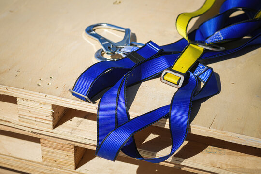 Safety harness device, falling prevention PPE to wear when working at height. Industrial safety equipment object, close-up with selective focus.