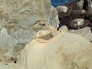 宮崎県日南市、断崖絶壁に鎮座する美しい神宮「鵜戸神宮」の神事、「運玉投げ」の的である「亀石」と呼ばれる岩のくぼみ