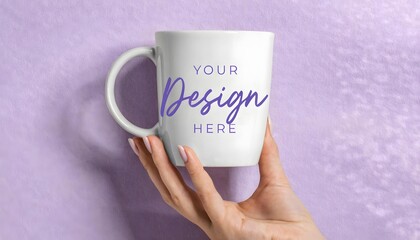 Hand holding a customizable white mug with 'Your Design Here' text against a soft purple background