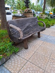Artistic wooden seating with natural branch armrests located in a landscaped park area