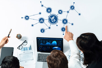 Team members collaborate on innovative green business strategies through data visualizations in a modern workspace, enhancing productivity and encouraging teamwork. Amity