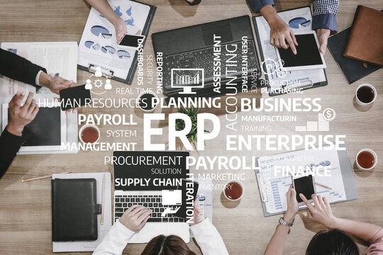 A team collaborates in a business meeting on enterprise resource planning, analyzing documents, discussing payroll, and strategizing for supply chain management. Tessel - Powered by Adobe