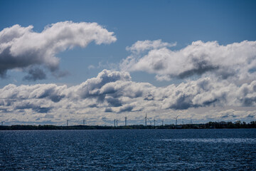 Offshore wind turbines under dramatic clouds over open water