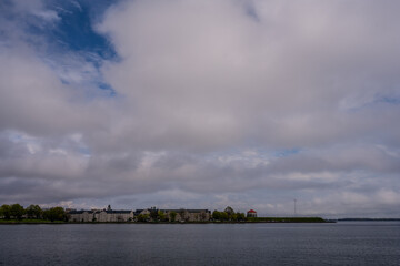 Fototapeta premium Waterfront buildings and fortification under cloudy sky