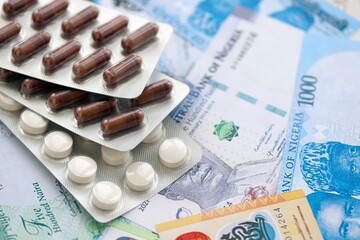 Nigerian naira currency money bills and medicine pills close up. The concept of medicine and pharmacy