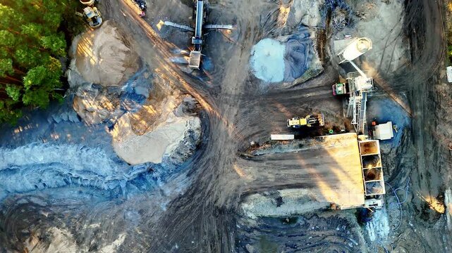 Drone aerial view of active gravel pit with aggregate processing machinery and heavy equipment