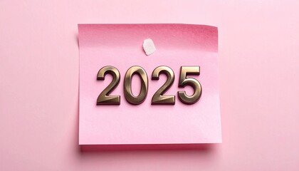 Gold "2025" numbers on a pink sticky note against pink background