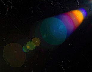 Lens flare effect with rainbow hues against a dark, scratched backdrop