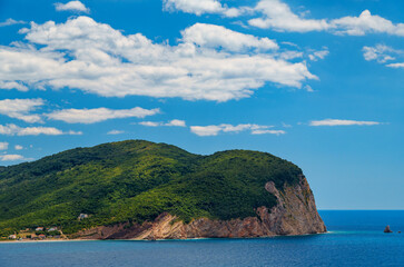 Naklejka premium beautiful seascape, view of sea and high cliff covered with forest in the distance