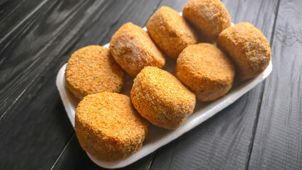 Fototapeta premium Freshly frozen breaded fish cakes. Round, semi-finished products, ready to cook.